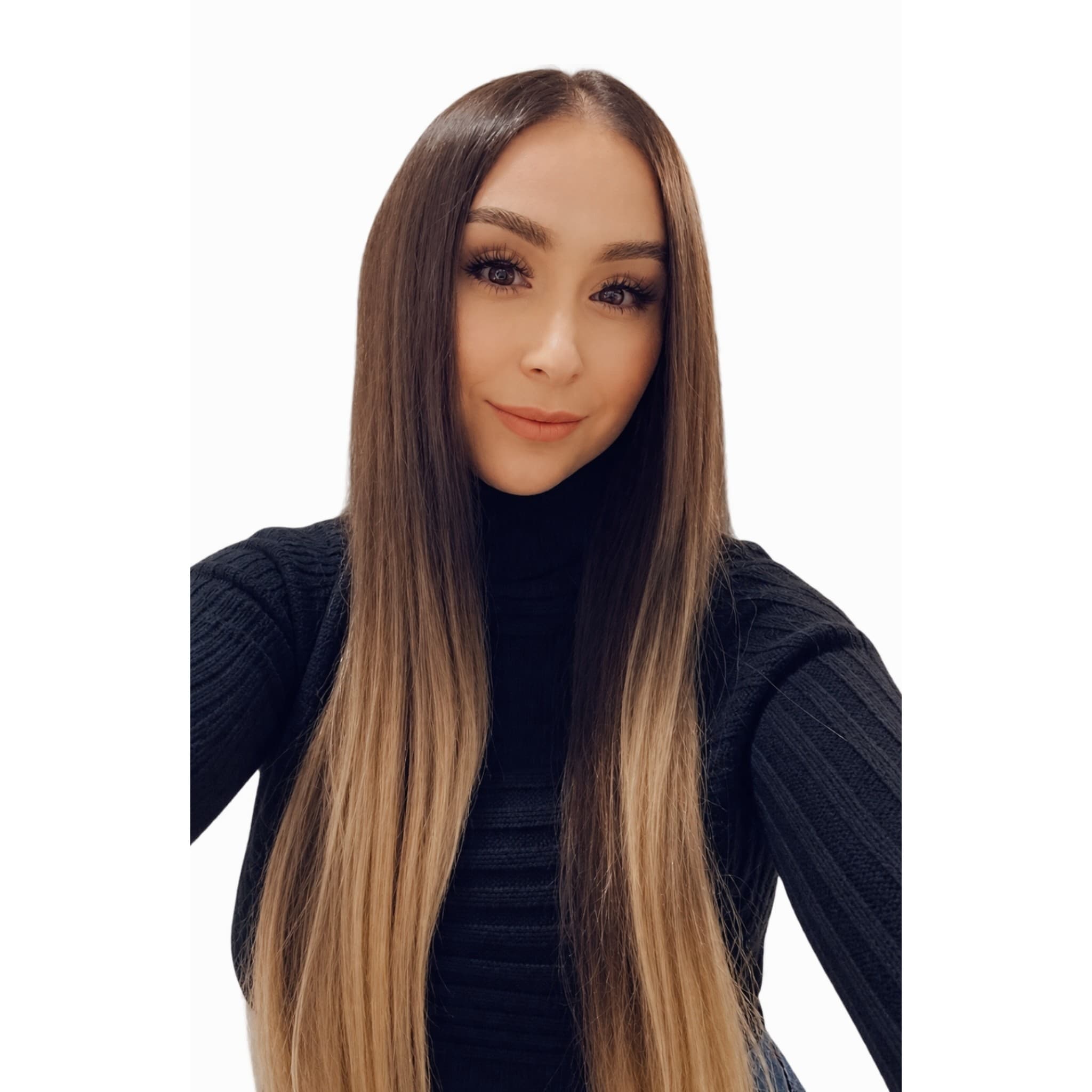 Woman with long, straight ombre hair wearing a black ribbed turtleneck sweater against white background.